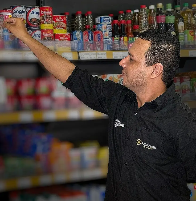 Repositor de uniforme Armazzem abastecendo a prateleira da loja